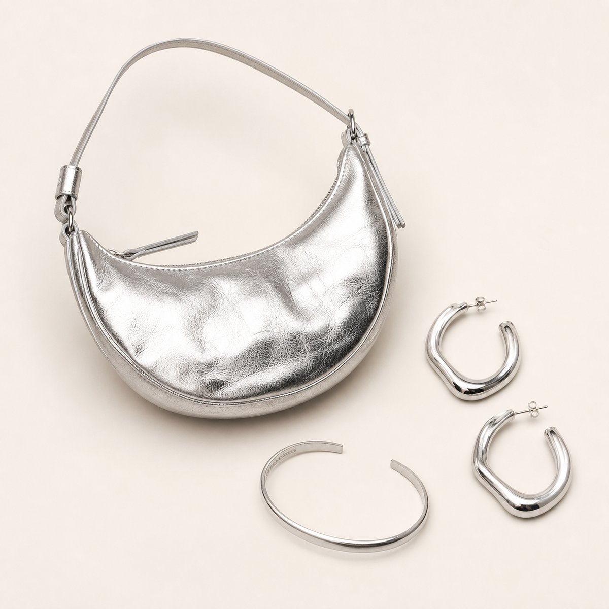 Synthetic silver handbag, hoop earrings and cuff wardrobe photograph